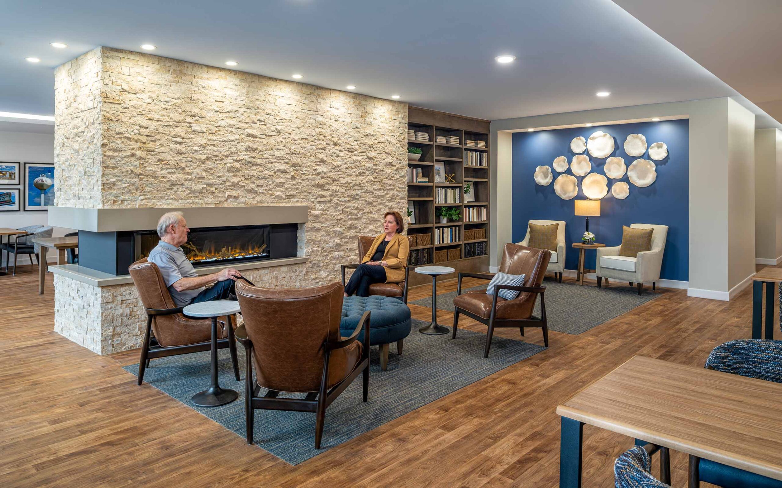 People sitting infront of a fireplace.