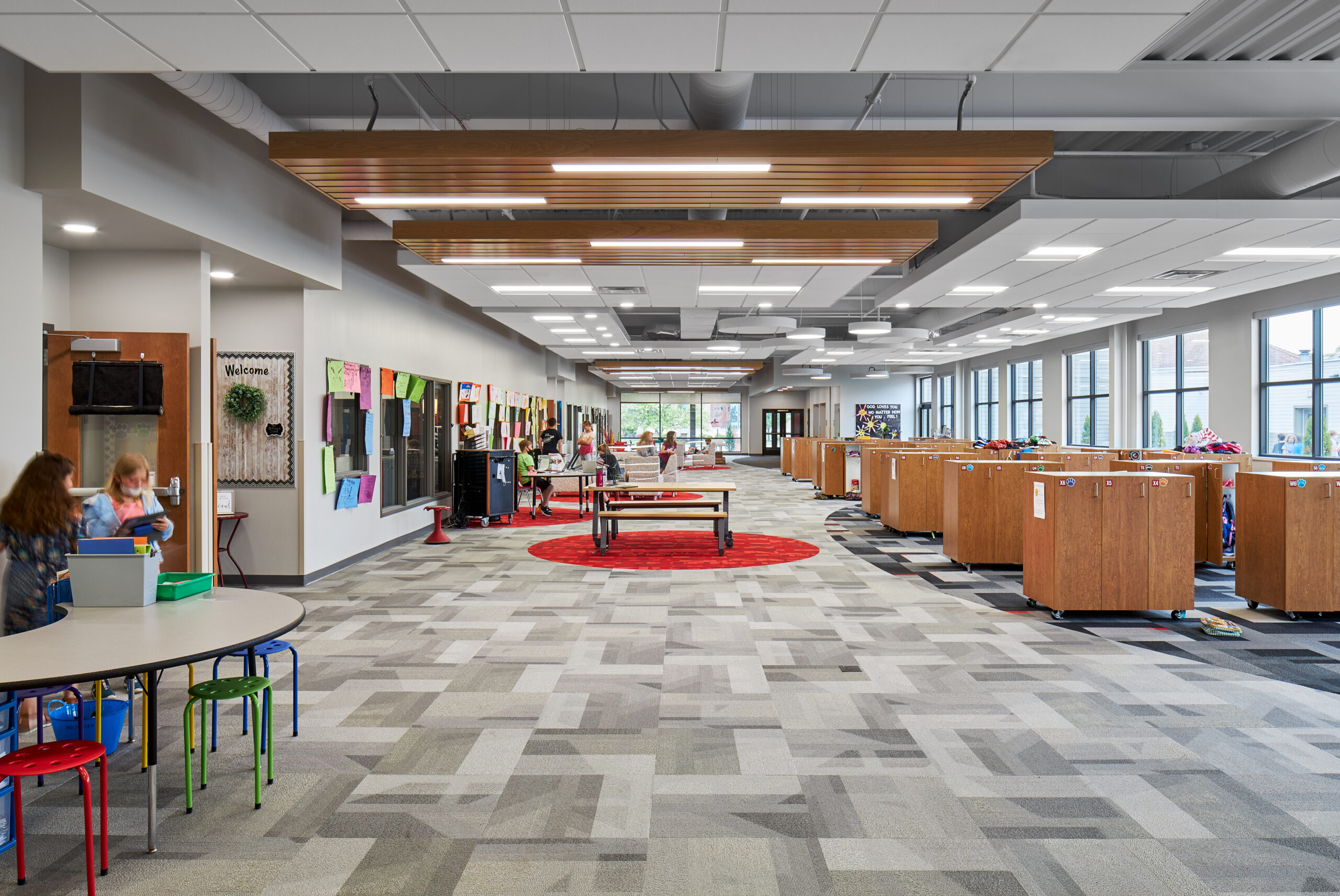 Expansive passing area with tables and lockers.