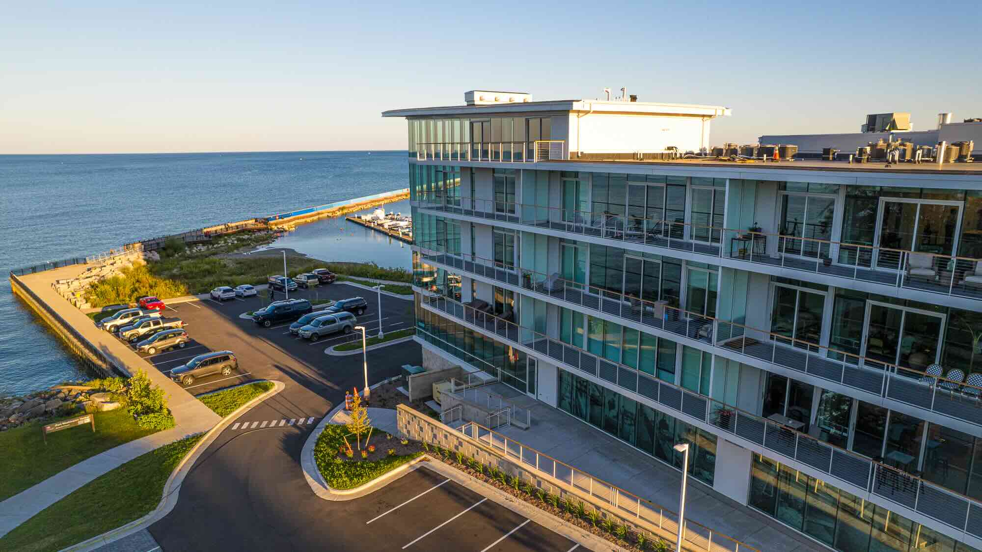 Exterior side drone shot of Newport Shores showing a 4-5 storied glass building.