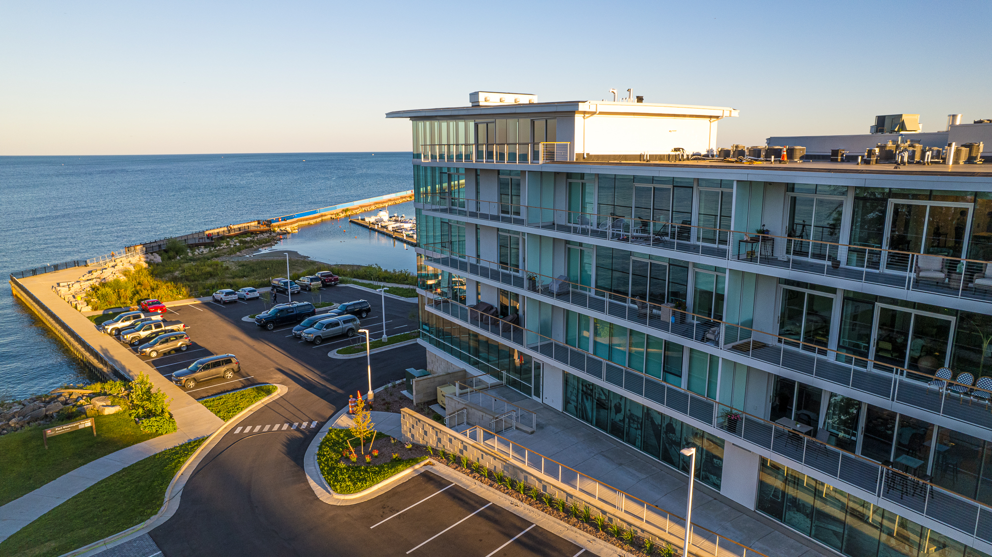 Exterior side drone shot of Newport Shores showing a 4-5 storied glass building.