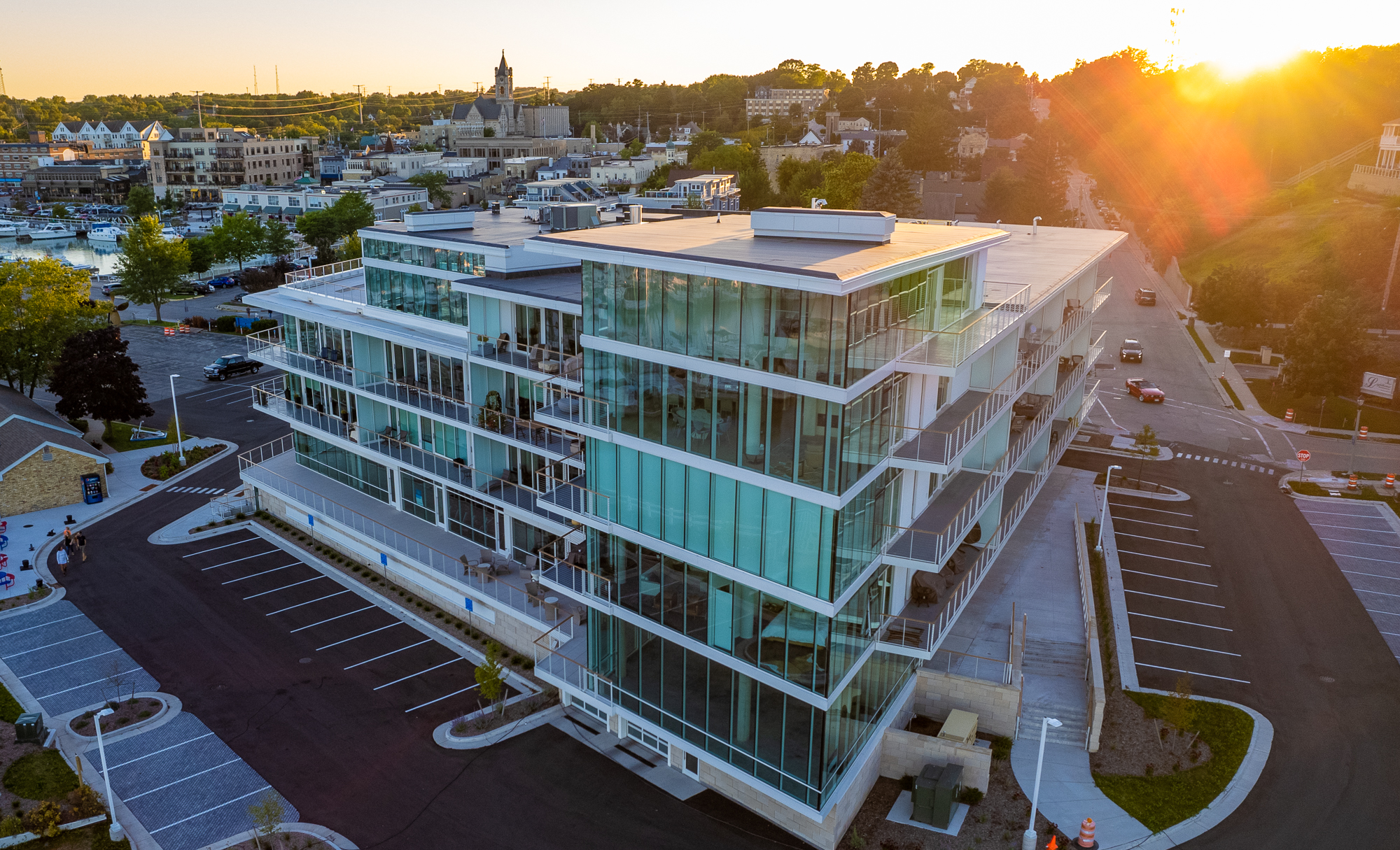 Exterior side drone shot of Newport Shores showing a 4-5 storied glass building.