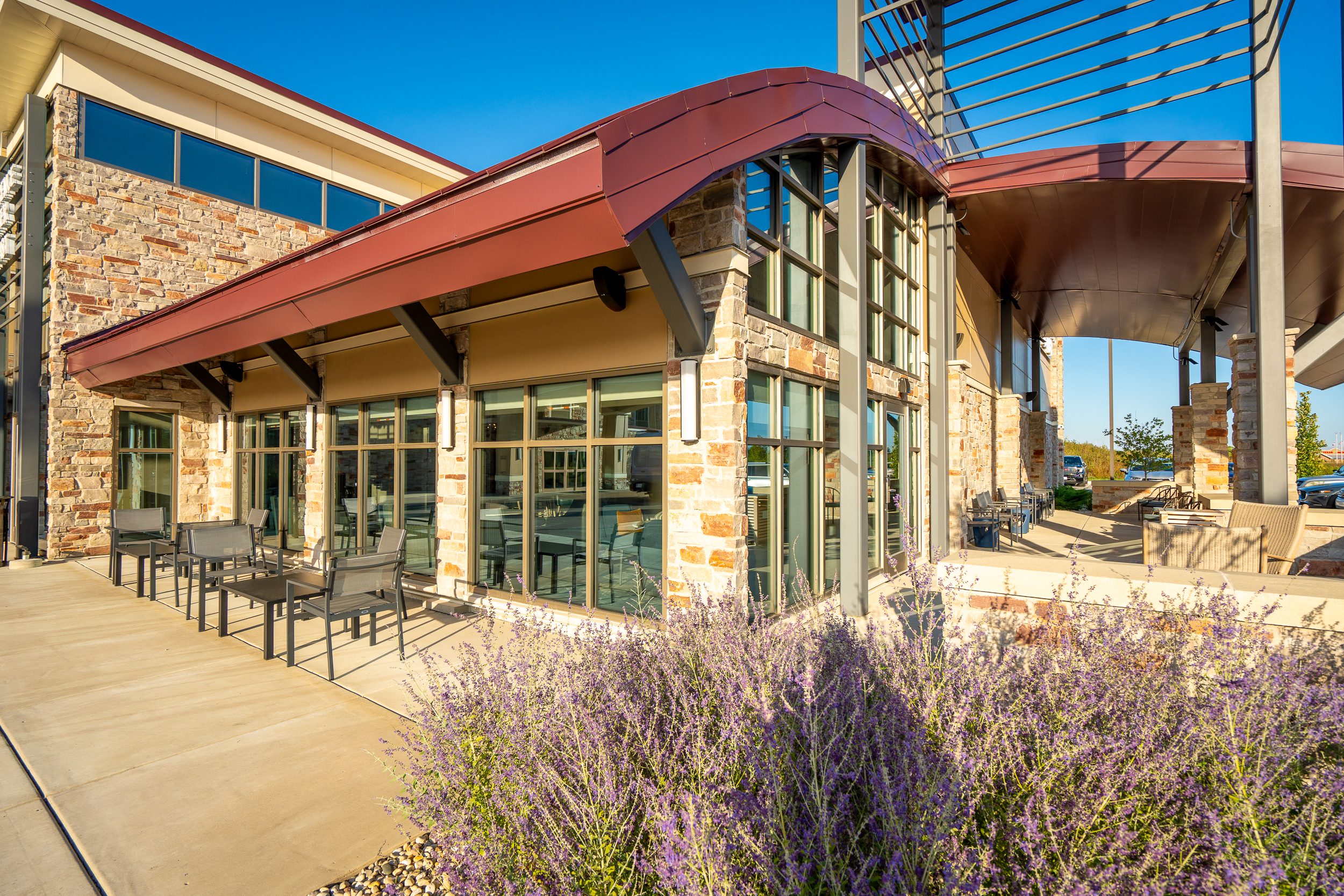 Exterior view of patio with large glass windows behind it.